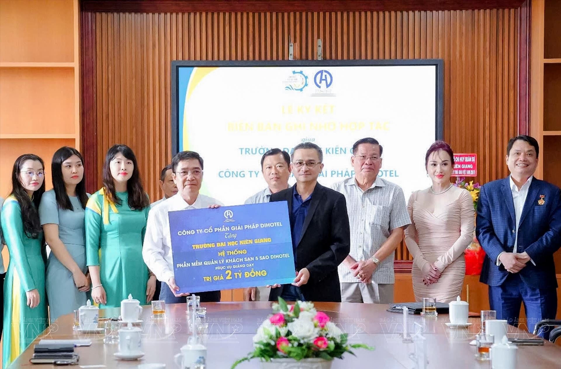 PGS, TS Nguyễn Trung Cang, Phó hiệu trưởng trường Đại Học Kiên Giang (bên trái) tiếp nhận (biểu trưng) phần mềm mang tên DiHotel và chương trình đào tạo miễn phí cho sinh viên ngành Du lịch do ông Nguyễn Vĩnh Tâm - Chủ tịch HĐQT Cty giải pháp DiHotel (bên phải) trao tặng. Ảnh Sỹ Dũng